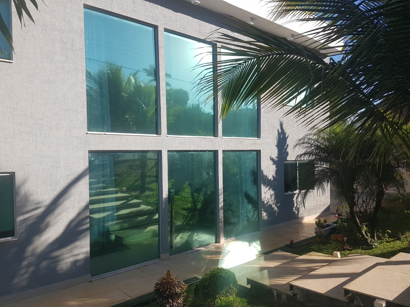 Fachada residencial com película de controle solar em janelas de vidro