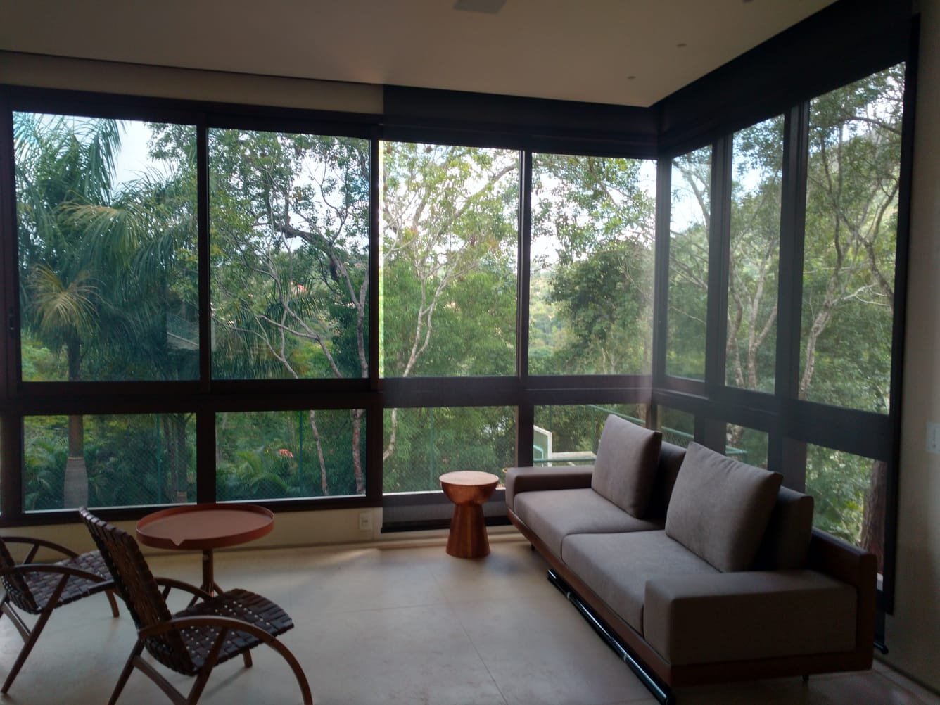 Sala residencial com grandes janelas de vidro e película aplicada